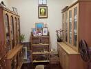 A cozy living room with wooden cabinets and a shelf displaying various items