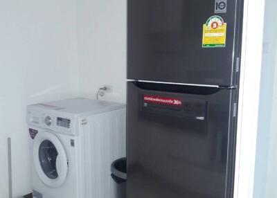 Laundry room with washing machine and refrigerator