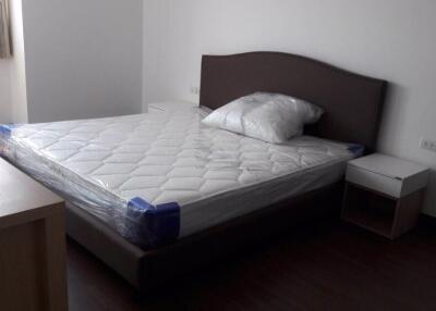 Bedroom with a bed, side table, and window