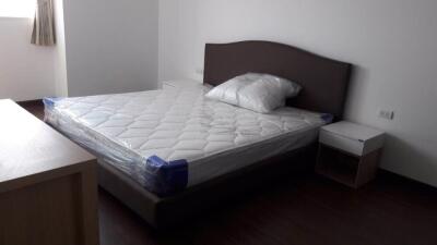 Bedroom with a bed, side table, and window