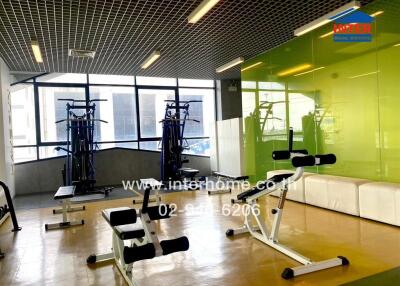 Modern gym with exercise equipment and large windows