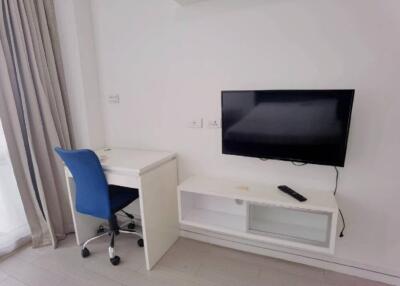 Bedroom with a desk, chair, and wall-mounted TV