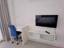 Bedroom with a desk, chair, and wall-mounted TV