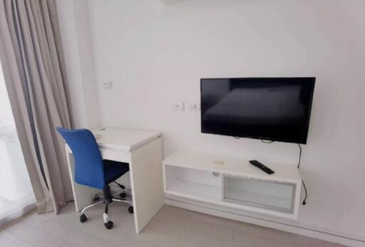 Bedroom with a desk, chair, and wall-mounted TV