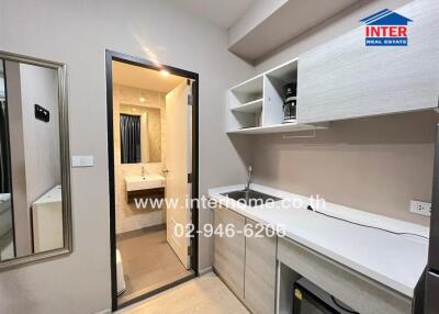 Modern kitchen with built-in appliances and view of adjacent bathroom