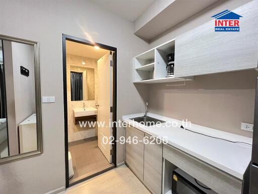 Modern kitchen with built-in appliances and view of adjacent bathroom