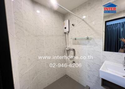 A modern bathroom with white tiled walls, a wall-mounted water heater, and a sink with a mirror