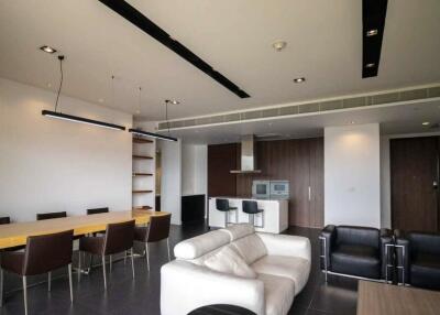 Modern living room with seating, dining, and kitchen area