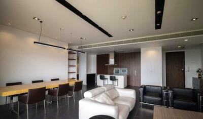 Modern living room with seating, dining, and kitchen area