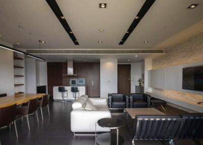 Modern living area with dining table, sofa, and bar stools