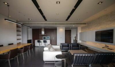 Modern living area with dining table, sofa, and bar stools