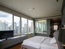 Spacious bedroom with large windows and city view