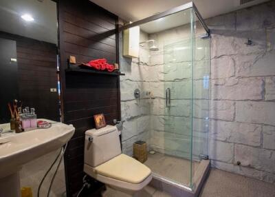 Modern bathroom with glass shower and dark wood accents