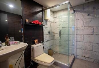 Modern bathroom with glass shower and dark wood accents