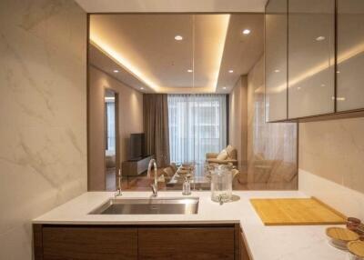 View of modern kitchen with marble and wood finishes, looking into living area