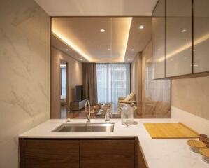 View of modern kitchen with marble and wood finishes, looking into living area