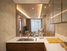 View of modern kitchen with marble and wood finishes, looking into living area