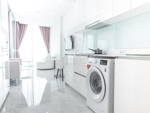 Modern kitchen with washing machine and a bright living area