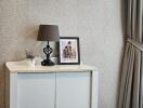 A corner of a bedroom with a cabinet and decorative items