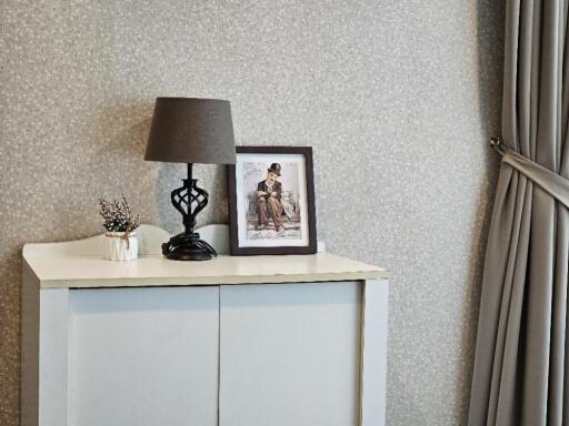 A corner of a bedroom with a cabinet and decorative items