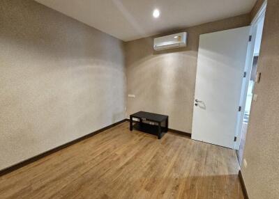 Empty room with wooden flooring and small table