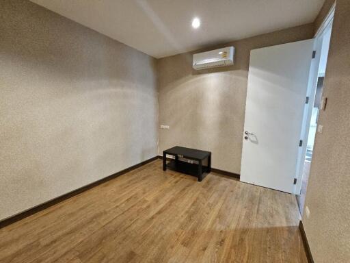 Empty room with wooden flooring and small table