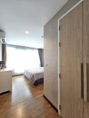 Modern bedroom with wooden flooring and natural light