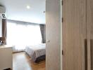 Modern bedroom with wooden flooring and natural light