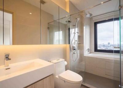 Modern bathroom with glass shower, toilet, and sink