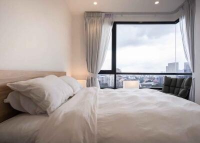 Cozy bedroom with large window and city view