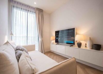 Cozy living room with a white sofa, large window, and a TV on a modern console