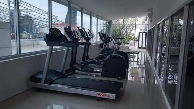 Modern indoor gym with exercise equipment and large windows