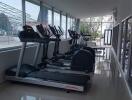 Modern indoor gym with exercise equipment and large windows