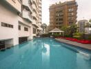 Outdoor swimming pool with building and seating area