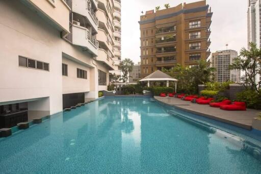 Outdoor swimming pool with building and seating area