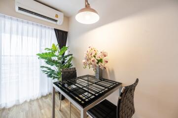 Modern dining area with a glass table and two chairs