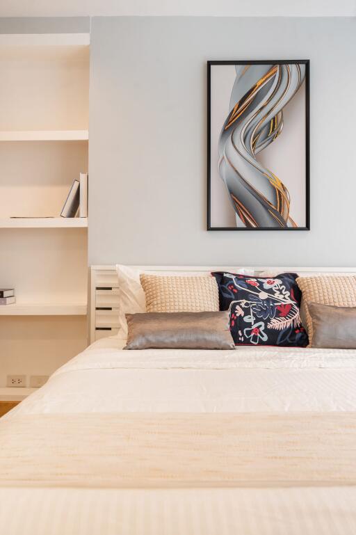 Modern bedroom with tidy bed, pillows, and wall art