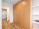 Spacious hallway with wooden cupboards and bookshelves