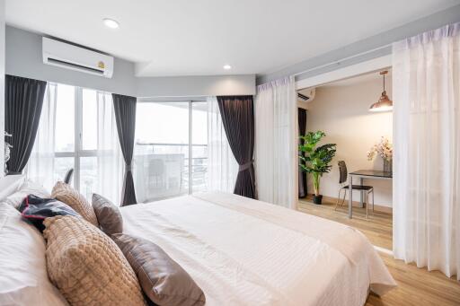 Spacious bedroom with large windows and balcony access