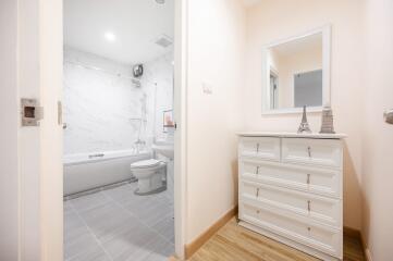 Modern bathroom with white fixtures and dresser