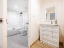 Modern bathroom with white fixtures and dresser