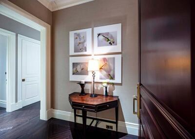 Well-lit hallway with artwork and wooden furniture