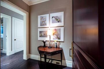 Well-lit hallway with artwork and wooden furniture