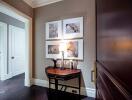 Well-lit hallway with artwork and wooden furniture