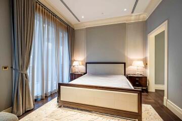 Well-lit bedroom with large window and elegant furnishings