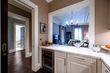 View of a small kitchen with a glimpse into a living area