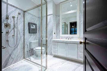 Modern bathroom with marble walls and glass shower