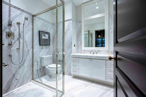 Modern bathroom with marble walls and glass shower