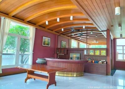 Spacious well-lit main living area with wooden ceiling and large windows