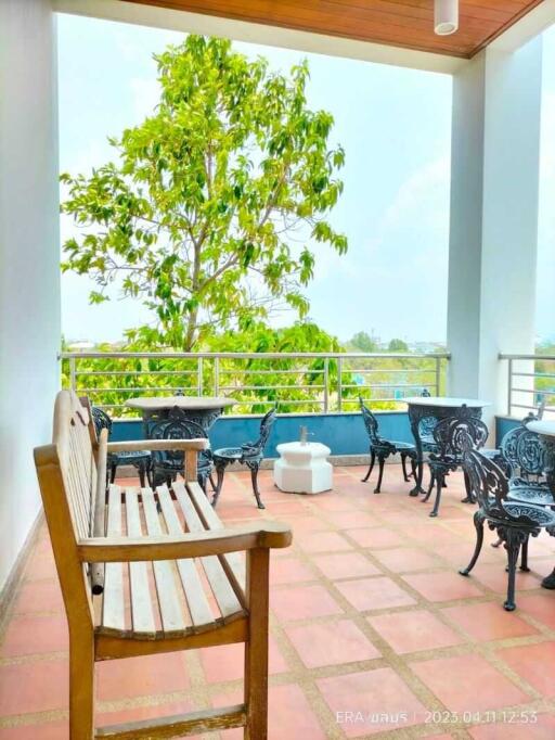 A spacious balcony with seating and a nature view